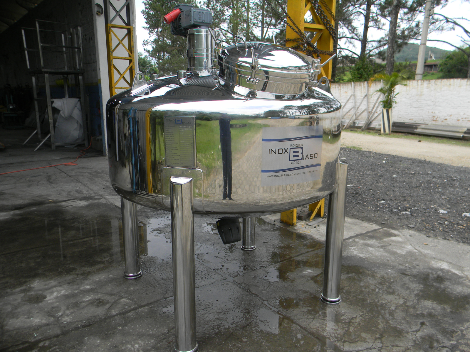 Tanque reator em aço inox Inox Biaso apoiado em quatro pés, instalado em área externa da fábrica para aplicações em processos químicos industriais