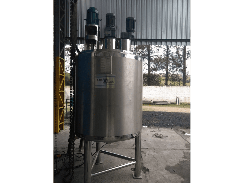 Reator químico industrial de grande porte em aço inox com três motoredutores superiores, instalado em galpão de produção da Inox Biaso