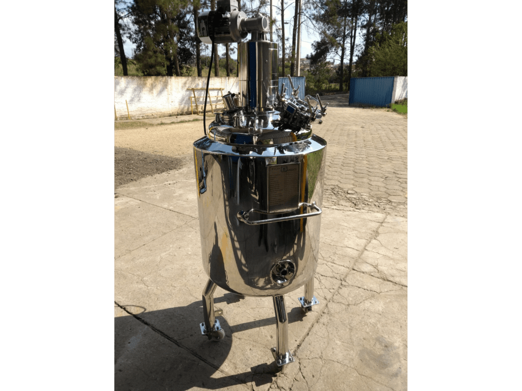 Reator químico industrial em aço inox com agitador mecânico superior e pés tubulares, instalado em área externa da fábrica Inox Biaso
